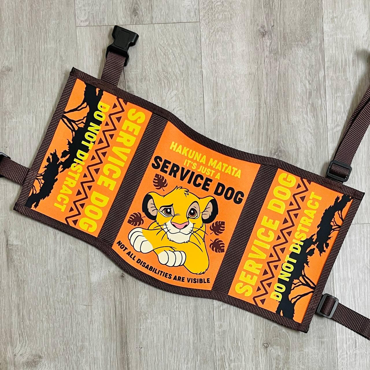 A dark blue service dog vest with Disney's Stitch and Angel artwork. The vest panels read: "Psychiatric service dog, not all disabilities are visible, access required by law" "Service dog in training, do not interact, give us space"